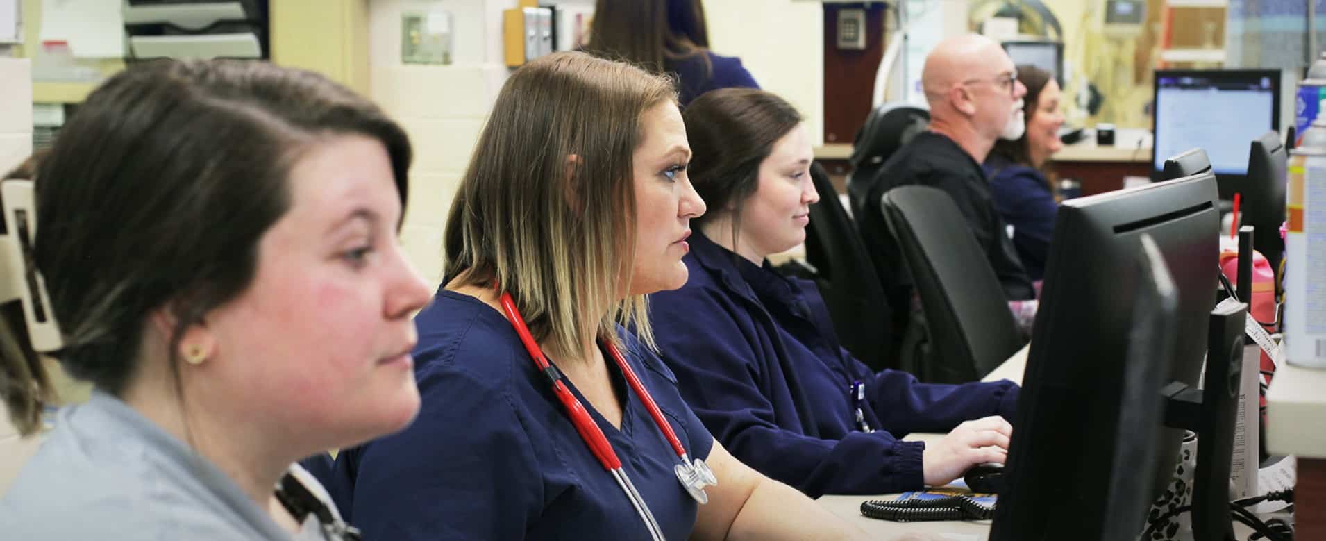 a group of people looking at a laptop