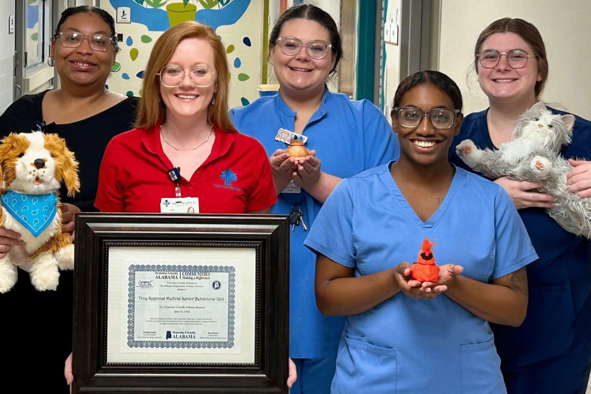 a group of people standing next to a teddy bear posing for the camera